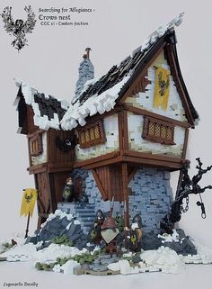 a building made out of legos is shown in front of a white background with snow on the ground