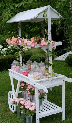 a white cart filled with lots of pink flowers