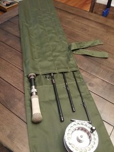 a fishing rod and reel laying on top of a green cover over a wooden table