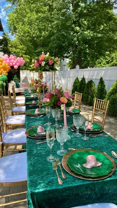 a long table set with green velvet cloths and place settings for formal dinner guests