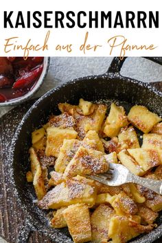 a skillet filled with french toast on top of a wooden table next to fruit