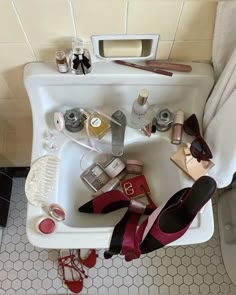 a bathroom sink filled with cosmetics and shoes