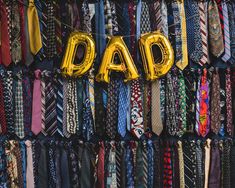 a bunch of ties with the word dad spelled out in gold foil letters on them