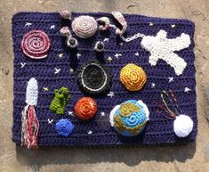 a crocheted space themed placemat on the ground