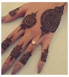 a woman's hand with henna tattoos on it