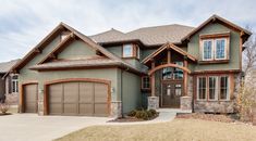 a large house with lots of windows and garage doors on the front side of it