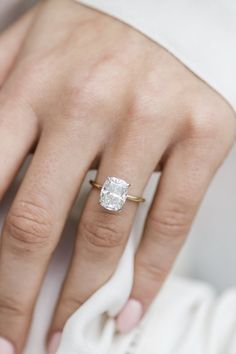 a woman's hand with a diamond ring on it