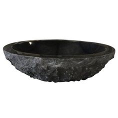 a black bowl sitting on top of a white wall