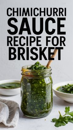 a jar filled with green sauce next to two bowls