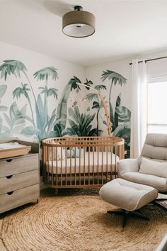 a baby's room with palm trees painted on the wall and a rocking chair