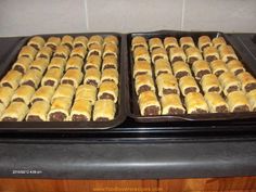 two trays filled with pastries sitting on top of a stove