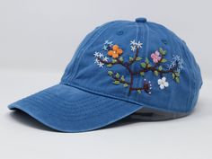 Flower is 100% hand embroidered on a 100% cotton wash baseball cap. Hat is one size fits all with adjustable back strap. Unique cap, one of a kind! I am also open for customization. If you want the item in different colors, please message me, it will take additional 2-3 days of handling time. Free first class shipping, upgradable priority mail service. 30 days return policy, feel confident at your purchase! Blue Embroidered Adjustable Trucker Hat, Blue Embroidered Baseball Cap, One Size Fits Most, Blue Embroidered Baseball Cap For Summer, Spring Blue Baseball Cap With Embroidered Logo, Blue Embroidered Visor Baseball Cap, Blue Embroidered Dad Hat With Curved Brim, Blue Baseball Cap With Curved Visor For Spring, Embroidered Blue Dad Hat Adjustable, Embroidered Blue Baseball Dad Hat