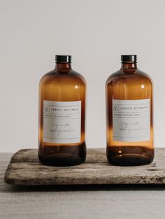 two brown bottles sitting on top of a wooden tray