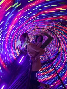 two people are standing in a colorful tunnel