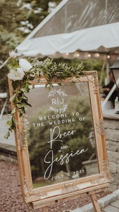 a wedding sign with greenery and flowers on the front is displayed in an old frame