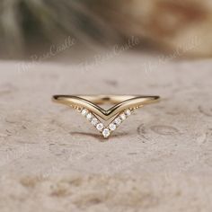 a diamond ring sitting on top of a stone surface with the word love written in it