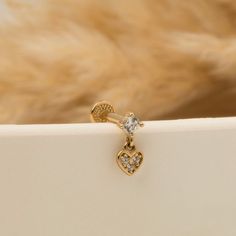 a close up of a gold ring with a diamond heart on the front and side