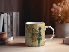 a coffee mug sitting on top of a wooden table next to a potted plant