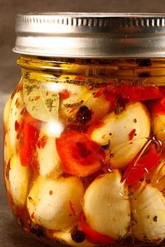 a jar filled with pickled onions and tomatoes