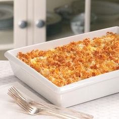 a casserole dish on a table with silverware