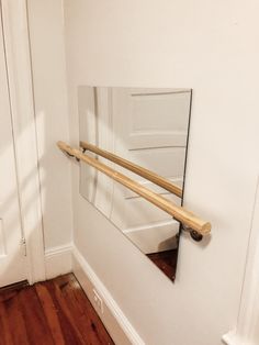 an empty room with a mirror on the wall and a wooden rail in front of it