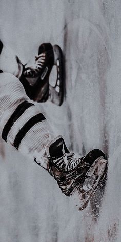 a pair of ice skates hanging off the side of a snow covered wall in winter