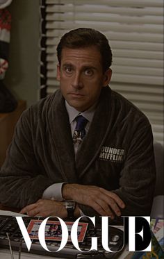 a man in a robe sitting at a desk with a keyboard and mouse on it