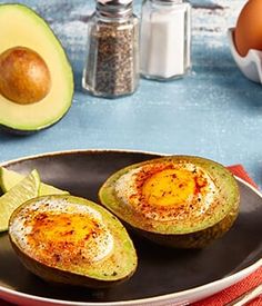 an avocado and eggs on a plate with other ingredients