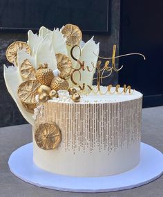 a white cake with gold decorations on top