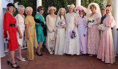 a group of women standing next to each other in dresses and bonnets on a porch