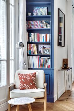 a living room filled with lots of books and furniture