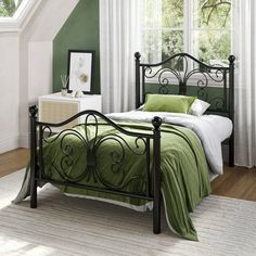 a bed room with a neatly made bed and green walls