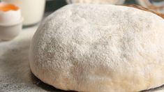 a ball of bread sitting on top of a table next to eggs and other ingredients