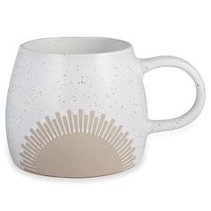 a white coffee mug with an intricate design on the outside and inside, in front of a white background