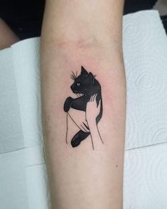 a black and white cat tattoo on the arm