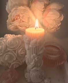 a candle is lit next to some flowers