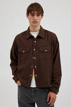 Western-inspired long sleeve shirt by BDG. Essential cotton shirt with a snap closure front. Collared shirt with Western look flap pockets and seamed yoke detailing. Urban Outfitters exclusive. Features BDG Western cropped long sleeve shirt Long sleeve snap front shirt Collared Western yoke accent Flap chest pockets Snap closure front Slightly cropped length UO exclusive Content + Care 100% Cotton Machine wash Imported Size + Fit Model in Brown is 6’1" and wearing size Medium Measurements taken Cropped Long Sleeve Shirt, Western Look, Cropped Long Sleeve, Collared Shirt, Shirt Long Sleeve, Shirt Collar, Collar Shirts, Flap Pocket, Snap Closure