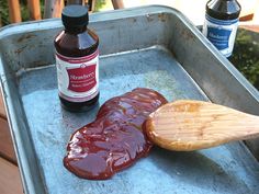 a wooden spoon sitting on top of a metal pan filled with sauce and ketchup