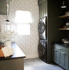 a washer and dryer sitting in a room next to a counter with towels on it