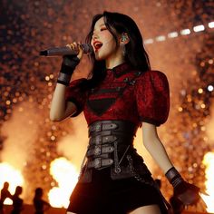 a woman in red and black outfit holding a microphone