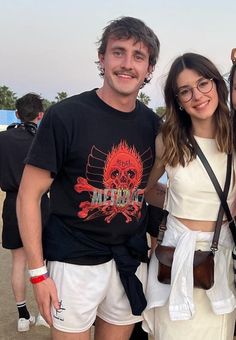 two people standing next to each other in front of a crowd at an outdoor event