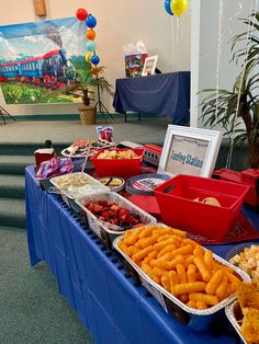 there are many trays of food on the table at this party, including pretzels and strawberries