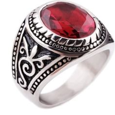 a silver ring with a red stone in the center and filigrees around it