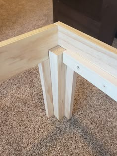 a wooden bench sitting on top of a carpeted floor