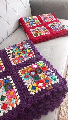 two crocheted blankets sitting on top of a white couch