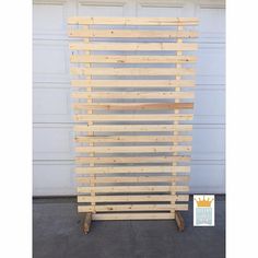 a large wooden slatted wall next to a garage door with a crown on it