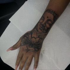 a hand with a buddha tattoo on it