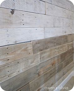 a wooden wall with white paint and wood planks on the bottom half of it