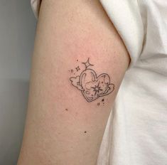 a small heart tattoo on the left arm