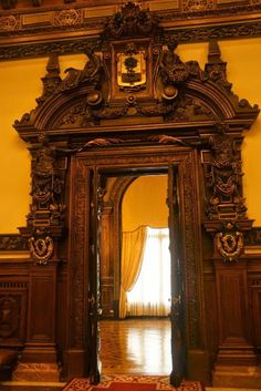 an ornate wooden mirror in the middle of a room